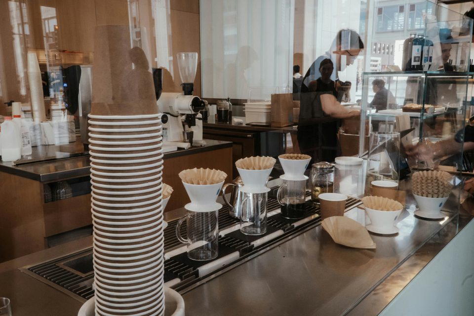Mostrador de una cafetería con la vitrina de pan y la barra de café.